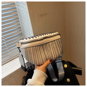 Détail du sac banane blanc avec rivets, franges métalliques et large bandoulière