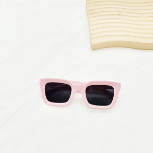 Vue de dessus de lunettes de soleil rectangulaires roses avec verres noirs sur tissu