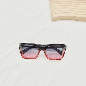 Détail de lunettes de soleil carrées dégradées sur un tissu blanc minimaliste