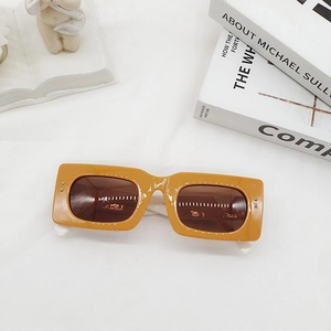 Detail of retro mustard yellow rectangle sunglasses with contrasting white temples