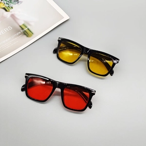 Square frame fashion sunglasses with red and yellow transparent lenses on a grey background