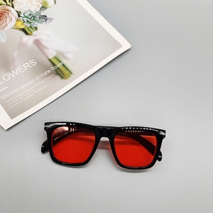 Detail view of fashion square sunglasses featuring red lenses and silver metal rivets