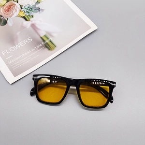 Detail shot of vintage square sunglasses with yellow lenses and silver metal temple accents