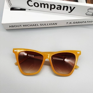 Detailed top view of bright orange sunglasses with metal stud accents on the frame