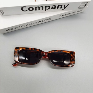 Top view of retro tortoiseshell square sunglasses with dark lenses on a grey background