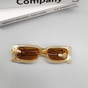 Detail of champagne gold square sunglasses with brown lenses and golden B-letter decoration