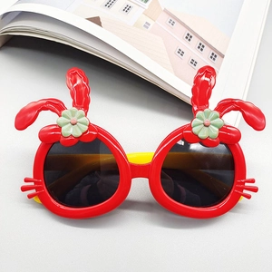 Close-up of red rabbit-shaped kids sunglasses with flower accents and yellow temples
