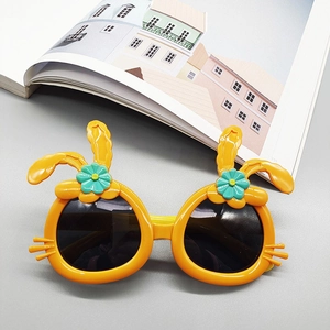 Detail of bright orange rabbit-eared sunglasses with small floral accents and dark lenses