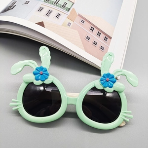 Close-up of mint green kids sunglasses with blue floral decor and cute rabbit ears