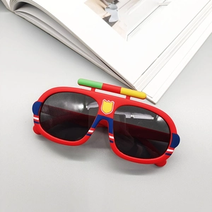Détail de lunettes de soleil rouges pour enfants avec icône de bouclier jaune et monture colorée