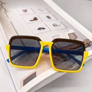 Detailed view of yellow and blue kids square sunglasses on a book background