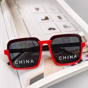Detail of square-frame kids sunglasses with red inner accent and dark lenses