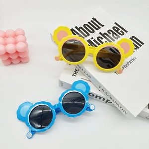 Detailed view of yellow and blue cartoon sun glasses with wave edges and cute ear frames