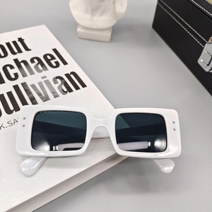 Détail de lunettes de soleil carrées blanches avec rivets argentés et verres foncés