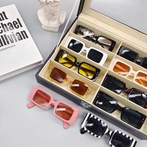 Lunettes de soleil rectangulaires à imprimé zèbre et couleurs variées sur livres d'art