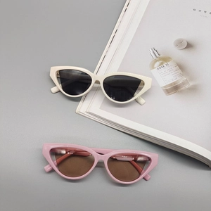 Chic cat-eye sunglasses with triangular frames in cream and pink on a minimalist background