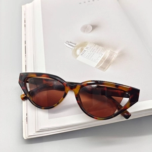 Detail of tortoise shell cat eye sunglasses with dark lenses on a magazine
