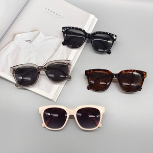 Set of retro oval sunglasses in black, grey, tortoiseshell and cream on magazine background