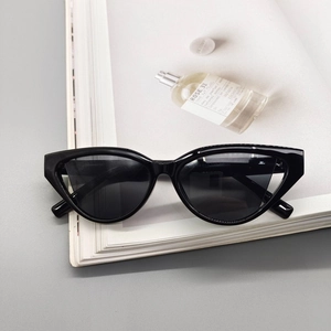 Close-up of black cat-eye sunglasses on a magazine with high-quality frame details