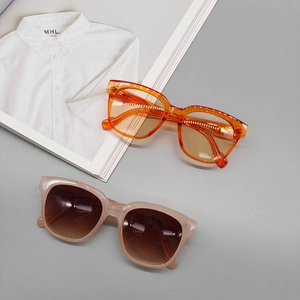 Retro oval sunglasses set in bright orange and pale pink frames with tinted lenses