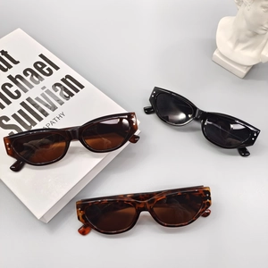 Vintage cat-eye sunglasses in black and tortoiseshell colors with silver dot accents