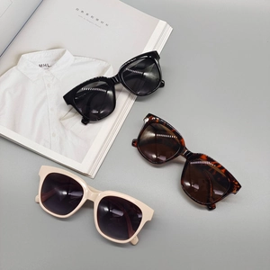 Detailed view of three vintage oval sunglasses in black, tortoise, and cream beige frames