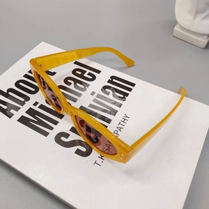 Retro small square sunglasses with bright yellow frames and dark lenses for a 90s vintage look
