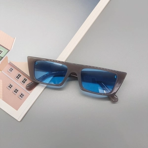 Détail de lunettes de soleil rectangulaires avec monture grise et verres bleus