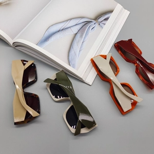 Flat lay of colorful thick-frame square sunglasses in tortoise, green, orange and red