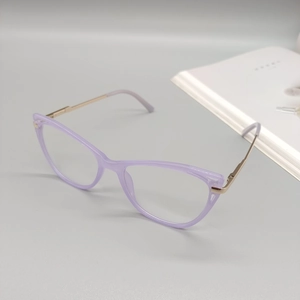 Détail de lunettes œil de chat lilas avec branches dorées sur fond gris neutre