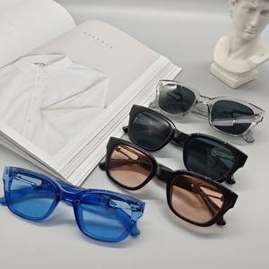 Chic square sunglasses in four trendy colors displayed on an artistic minimalist setup