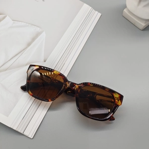 Detail of tortoise square sunglasses with brown lenses on aesthetic background