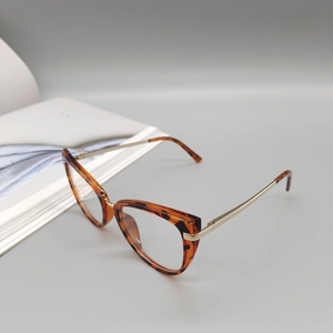Detailed view of leopard print cat-eye frames with stylish gold metal temple hinges