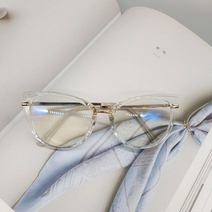Detail of transparent cat-eye frame with elegant gold floral engraved metal temples