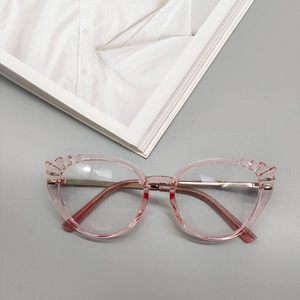 Détail de lunettes œil-de-chat roses en TR90 avec bords ondulés sur un magazine