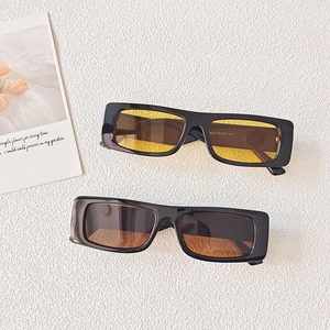 Detail of vintage square sunglasses with black thick frames and yellow or brown lenses