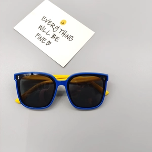 Flat lay of polarized kids sunglasses in vibrant blue and yellow contrast frame