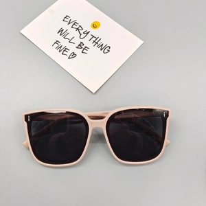 Detail shot of beige square children's sunglasses with silver rivet accents and polar lenses