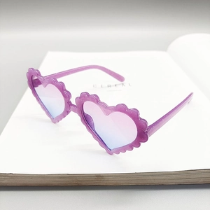 Detail of purple heart-shaped sunglasses with glitter frame and gradient lenses