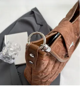 Macro detail of brown quilted fabric texture and premium silver circular metal buckle