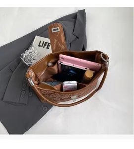 Spacious interior of brown quilted tote bag showing storage for tablet and essentials