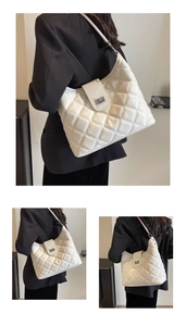 Close-up of white quilted PU leather shoulder bag with a silver metallic turn-lock closure