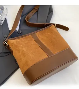 Detail of retro brown bucket bag featuring premium suede and leather patchwork design