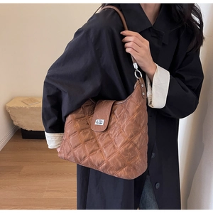 Close-up of brown quilted hobo bag with silver twist lock and minimalist design
