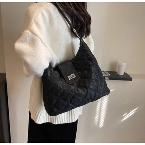 Detail of black quilted hobo bag with camouflage pattern and silver metal twist lock