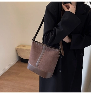 Detail view of brown vintage bucket bag featuring suede leather contrast and adjustable strap