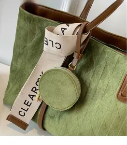 Detail of green suede tote bag with brown leather straps and decorative canvas band