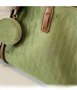 Detailed close-up of grass green quilted tote bag fabric with brown leather handles
