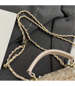 Detailed view of the woven tweed texture and classic leather-intertwined chain strap