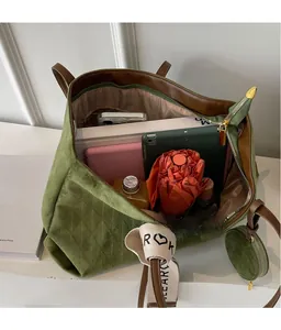 Detail of green velvet tote bag showing spacious interior with books and quilted pattern